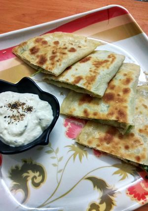 A picture of Aloo Afghani Bolani served with cheesy yoghurt sauce.