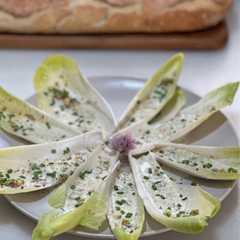 Una foto de Endivias con salsa de roquefort y pistachos