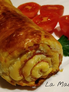 Una foto de Rollo de hojaldre relleno de jamón, huevo duro, olivas y queso