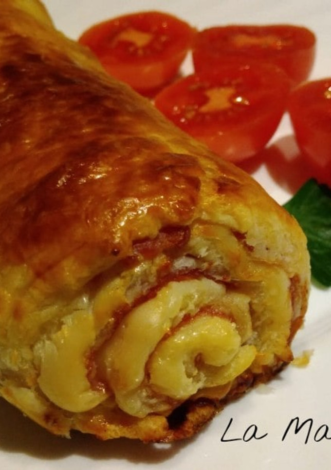 Una foto de Rollo de hojaldre relleno de jamón, huevo duro, olivas y queso