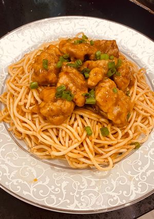 A picture of Orange Chicken with spicy spaghetti.