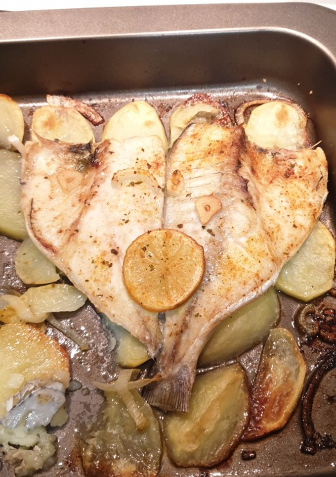 Una foto de Dorada al horno con finas hierbas, limón y patatas asadas 🤩