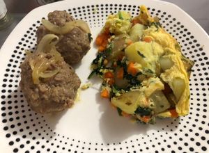 Una foto de Albóndigas de cadera de res encebollada acompañada de tortilla española de espinaca y papa rústica