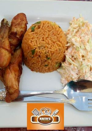 A picture of Jollof rice with coleslaw and chicken.