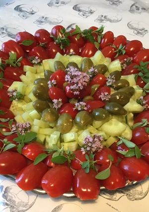 Une photo de Salade de tomates cerises, concombre,câpres italiennes et basilic en fleur