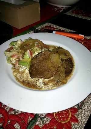 Una foto de Bistec encebollado al vino.