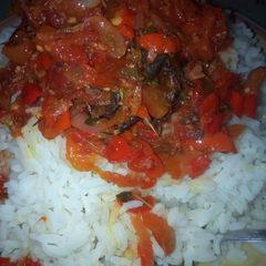 A picture of Rice and tomatoes sauce.