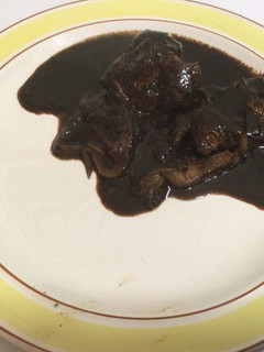 Una foto de Carne de puerco con setas en mole negro