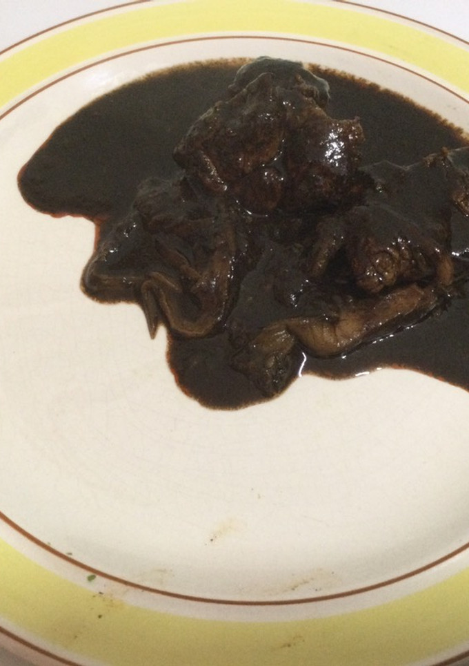 Una foto de Carne de puerco con setas en mole negro