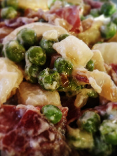 Una foto de Guisantes y patatas salteados con jamón y ajos tiernos