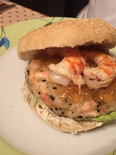Una foto de Hamburguesa de salmón y gambas con salsa de eneldo y cebolla caramelizada