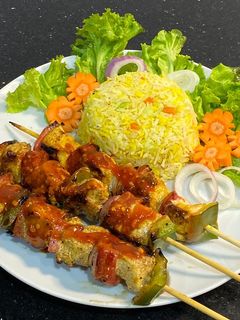 A picture of Chicken shashlik with vegetable fried rice.