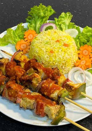 A picture of Chicken shashlik with vegetable fried rice.