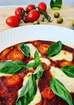 Une photo de Pizza au basicilic mozarrella et tomates fraîches
