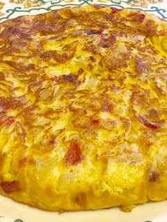 Una foto de Tortilla de patatas con cebolla, pimiento y jamón