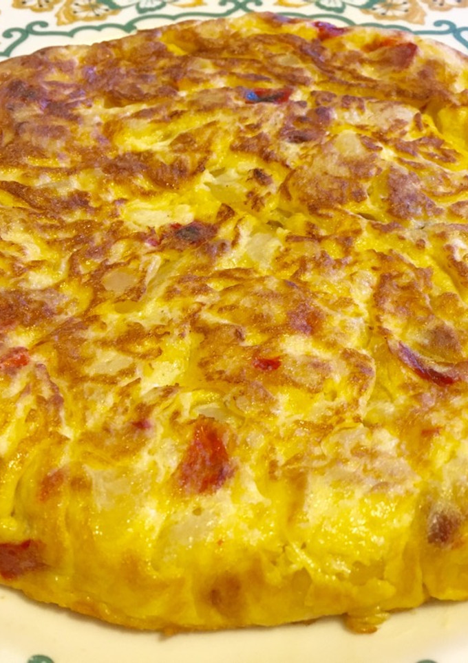 Una foto de Tortilla de patatas con cebolla, pimiento y jamón