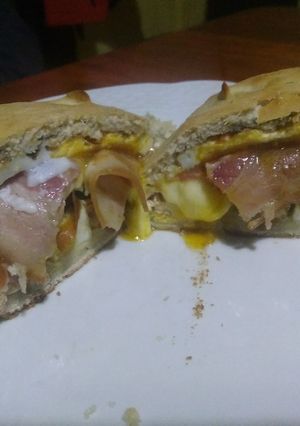 Una foto de Panarrolladodepollo con muzzarella, panceta, huevo frito y verduras