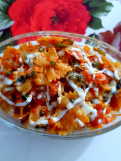 A picture of Farfalle Pasta with cheese & Schezwan sauce.
