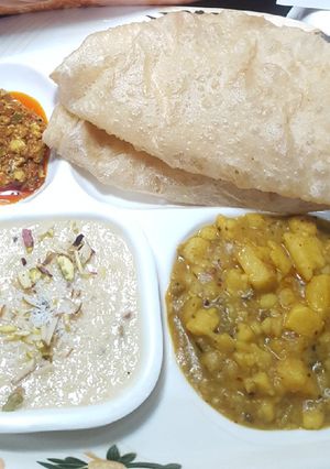 A picture of Soft Puri with Aloo ki bhujiya, Kheer & achar.