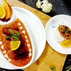 A picture of Sour & spicy fruit gobhi awadhi in orange gravy.