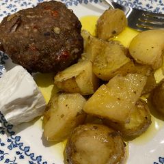 A picture of Greek burgers with potatoes.