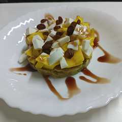 Una foto de Tartar de salmón y aguacate con mango, pasas y queso fresco