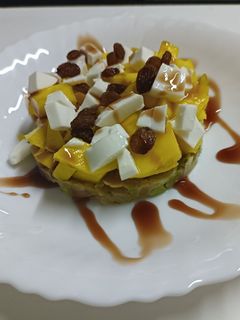 Una foto de Tartar de salmón y aguacate con mango, pasas y queso fresco