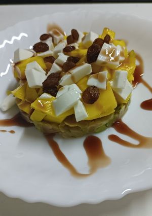 Una foto de Tartar de salmón y aguacate con mango, pasas y queso fresco