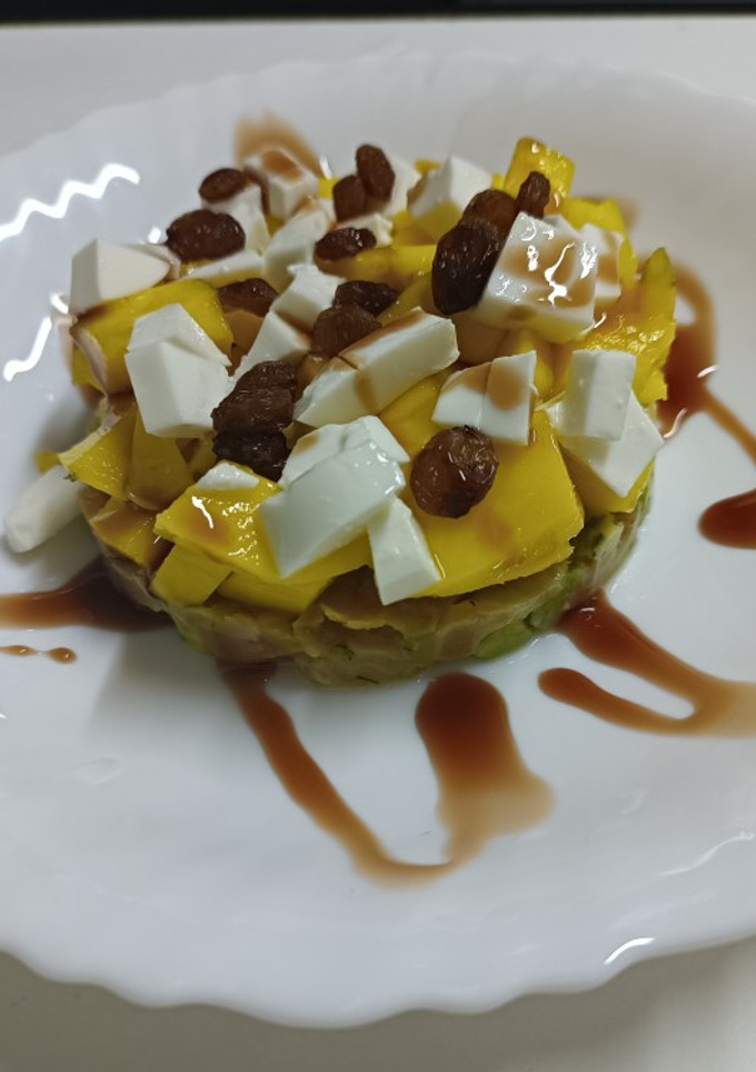 Una foto de Tartar de salmón y aguacate con mango, pasas y queso fresco