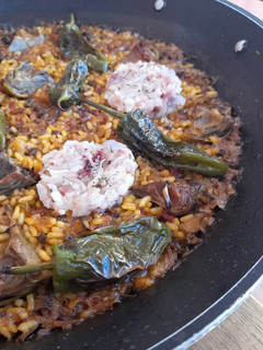 Una foto de Arroz seco de pies de cerdo, alcachofas y pimientos del padrón