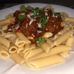 A picture of Penne pasta with meat ball sauce.