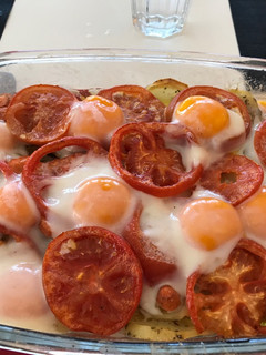 Una foto de Patatas asadas con tomate y huevos al horno