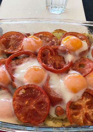 Una foto de Patatas asadas con tomate y huevos al horno