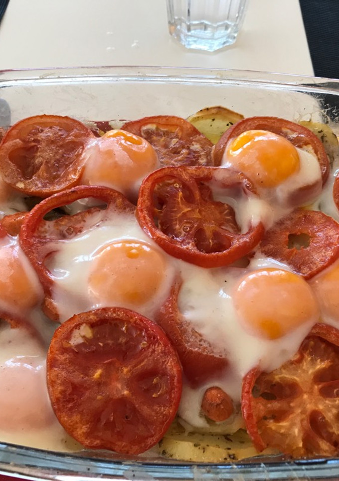 Una foto de Patatas asadas con tomate y huevos al horno