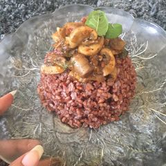 A picture of Red rice with mushroom and basil.