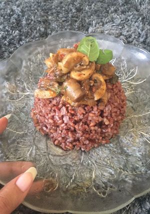 A picture of Red rice with mushroom and basil.