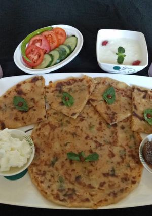 A picture of Aloo parantha with curd and rose sweet lassi.