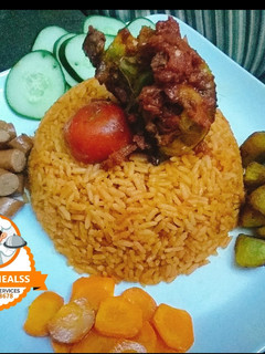 A picture of Jollof rice with boiled carrot,and grilled Chicken.