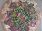 Una foto de rúcula pizza