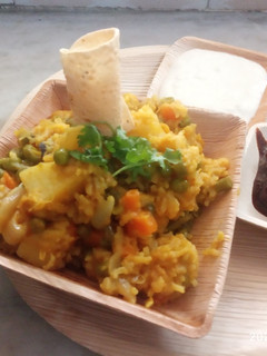 A picture of Veg khichdi with curd and sweet sour mango pickle.