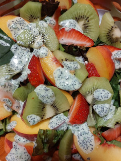 Una foto de Ensalada veraniega de hojas verdes y frutas frescas