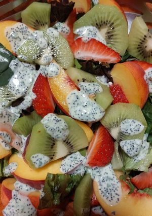 Una foto de Ensalada veraniega de hojas verdes y frutas frescas