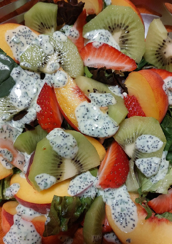 Una foto de Ensalada veraniega de hojas verdes y frutas frescas
