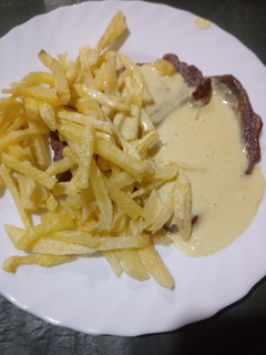 Una foto de Bifes a la plancha, con papas fritas y salsa de mostaza y crema