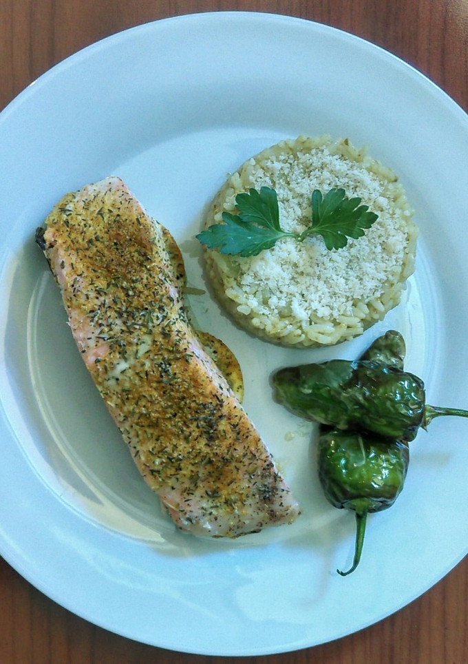 Una foto de Salmón marinado en papillote, arroz con pesto y pimientos de padrón fritos