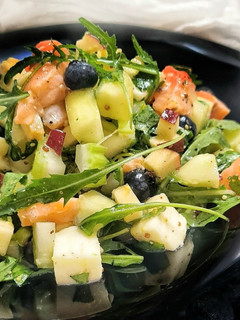 Una foto de Ensalada con pepino, salmón marinado y arándanos