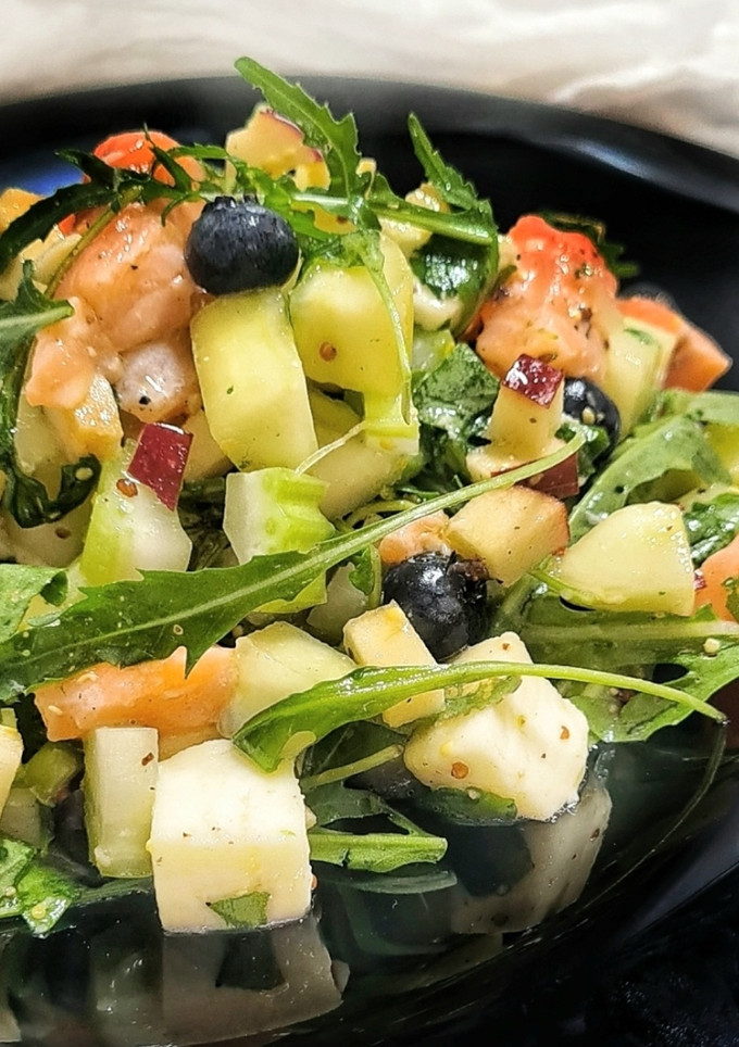Una foto de Ensalada con pepino, salmón marinado y arándanos