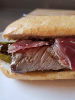 Una foto de Bocata o sándwich de ternera, jamón serrano y pimientos