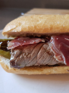 Una foto de Bocata o sándwich de ternera, jamón serrano y pimientos