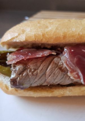 Una foto de Bocata o sándwich de ternera, jamón serrano y pimientos